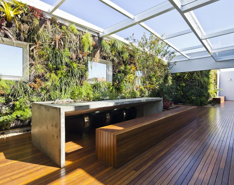 Jardim vertical com cobertura de vidro por Casa 14 Arquitetura