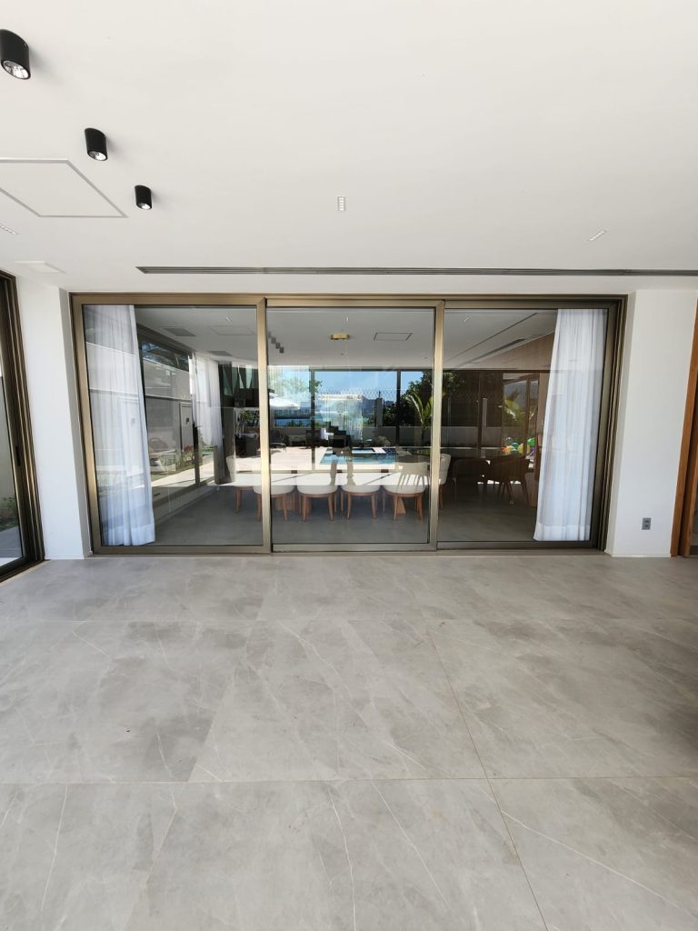 Esquadria Euroshow, portas em alumínio de alto padrão com anodização inox e vidro laminado neutro de controle solar