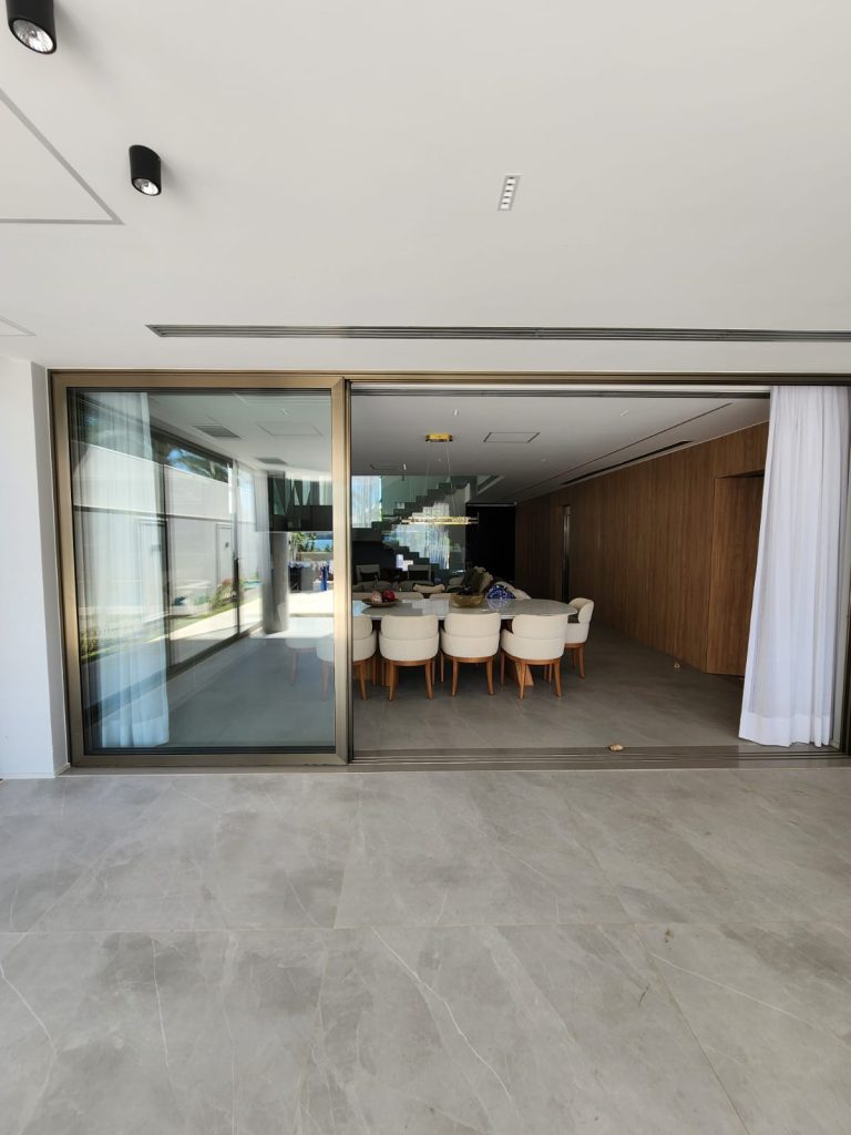 Esquadria de alumínio Euroshow, portas de alto padrão com anodização inox e vidro laminado neutro de controle solar